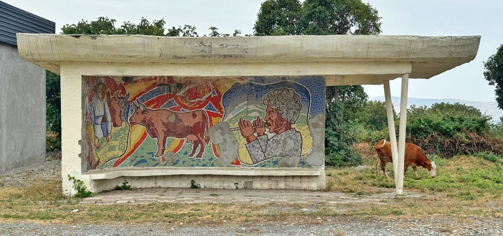 Large mosaic panel at a Soviet-era bus stop in Sheki, Azerbaijan, depicting Shepards and farmers in socialist realist style.